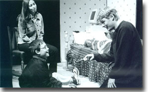 Sex offender Paul (Richard Hasnip) offers a present to  Kieron (John Nicol) as Kieron's mum Suzanne (Nikki Hill) looks  on